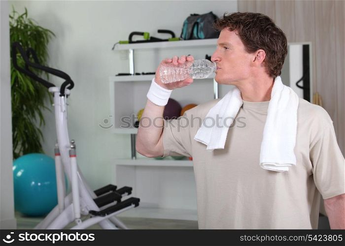 Man drinking water after tough gym session