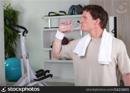 Man drinking water after tough gym session