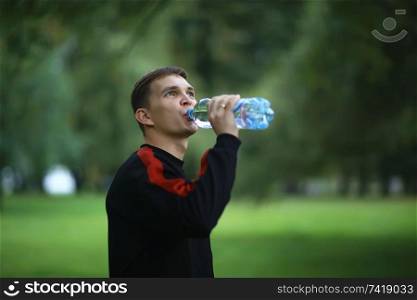 man drinking water bottle park