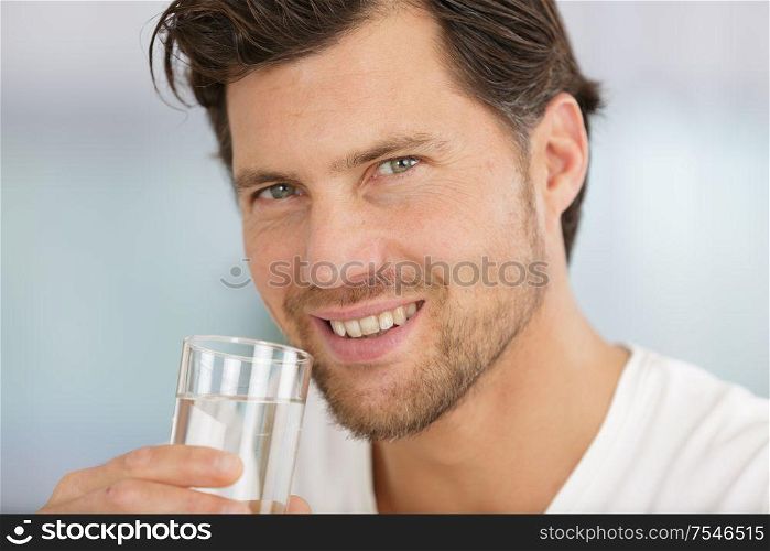 man drinking water from a glass