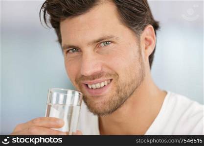 man drinking water from a glass