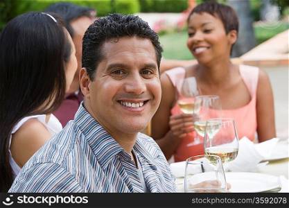 Man drinking wine with friends outdoors