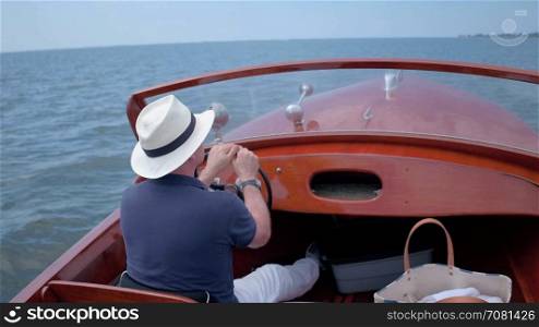 Man driving a beautiful retro boat