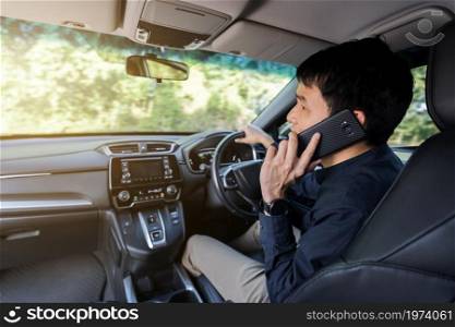 man driving a car and talking on a mobile phone