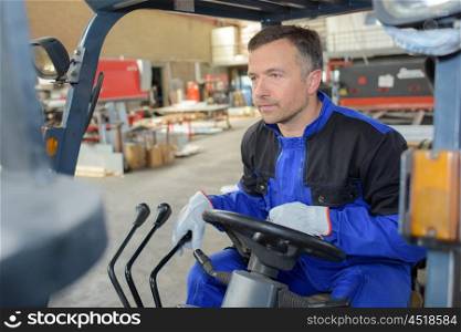 man driving a machine in the warehouse