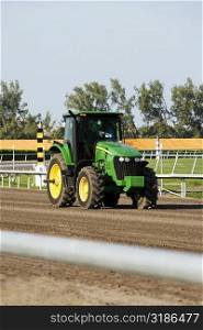 Man driving a tractor on a horseracing track