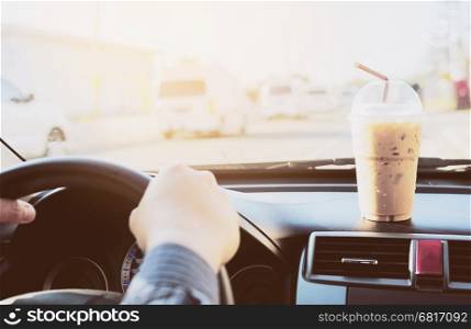 Man driving car with cup of cold coffee
