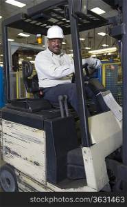 Man driving fork lift truck in newspaper factory