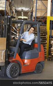 Man Driving Fork Lift Truck In Warehouse