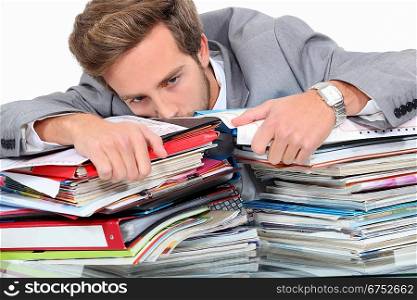 Man drowning in stacks of paperwork