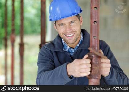 man during installation of metal pipes