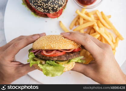 Man eating burgers at table, pov view