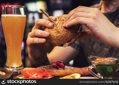 Man eating burgers. Man eating burgers at table at cafe