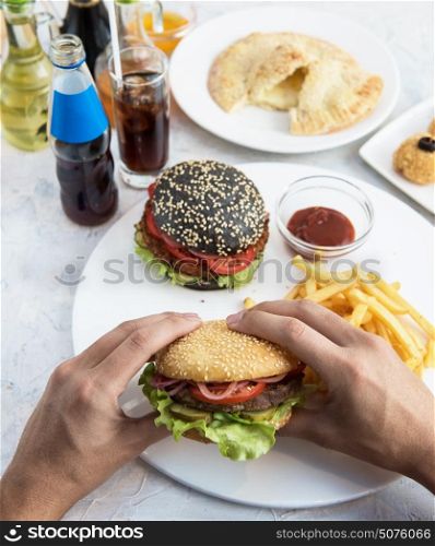 Man eating burgers. Man eating burgers at table, pov view