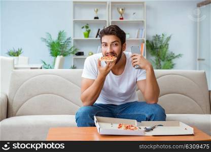 Man eating pizza having a takeaway at home relaxing resting
