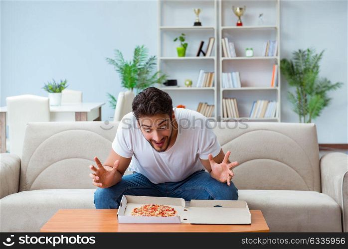 Man eating pizza having a takeaway at home relaxing resting