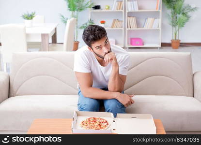 Man eating pizza having a takeaway at home relaxing resting