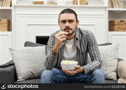man eating popcorn watching tv