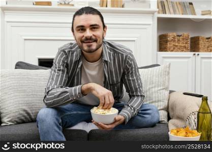 man eating popcorn watching tv front view
