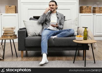 man eating popcorn watching tv long shot