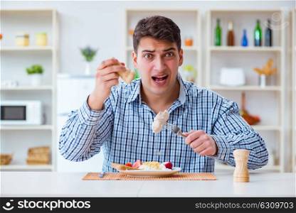 Man eating tasteless food at home for lunch