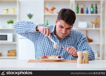 Man eating tasteless food at home for lunch