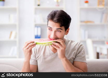 Man eating watermelon at home