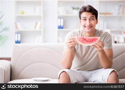 Man eating watermelon at home. The man eating watermelon at home