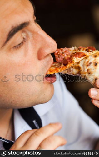 Man eats pizza. Close up pizza piece in hand