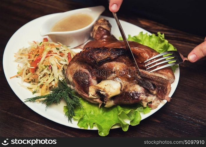 Man eats tasty dish of pork shank. Man eats tasty dish of pork shank, closeup photo
