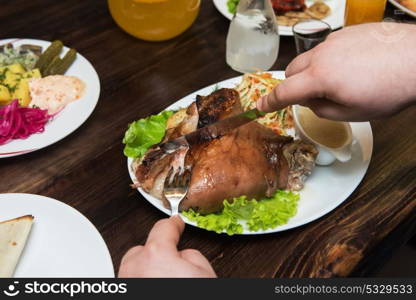 Man eats tasty dish of pork shank. Man eats tasty dish of pork shank, closeup photo