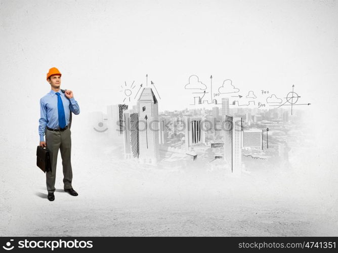 Man engineer. Image of man engineer in helmet with drafts. Construction concept