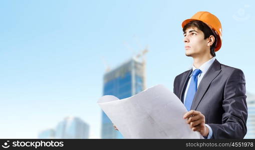 Man engineer. Young man architect looking at construction project