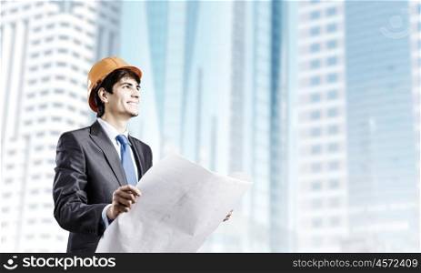 Man engineer. Young man architect looking at construction project