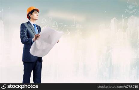 Man engineer. Young man architect looking at construction project