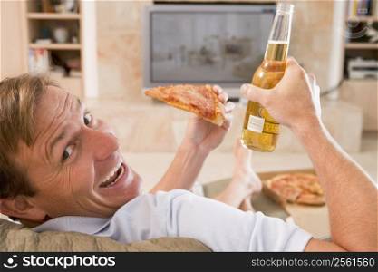 Man Enjoying Beer And Pizza In Front Of TV