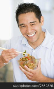 Man Enjoying Chinese Food With Chopsticks