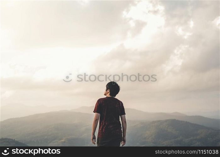 Man Enjoying Freedom on top of mountain with sunset relaxation concept