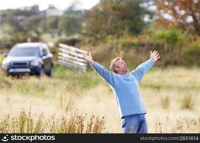 Man Enjoying Freedom Outdoors in Autumn Landscape