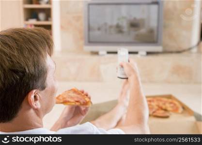 Man Enjoying Pizza While Watching TV