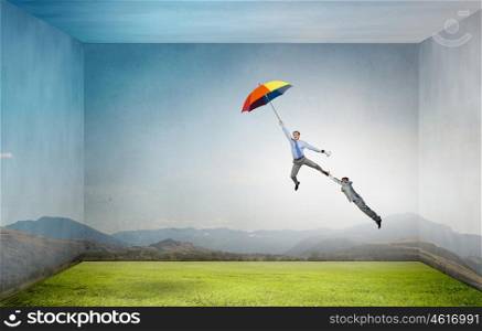 Man escaping on umbrella. Man trying to catch another who flying on colorful umbrella