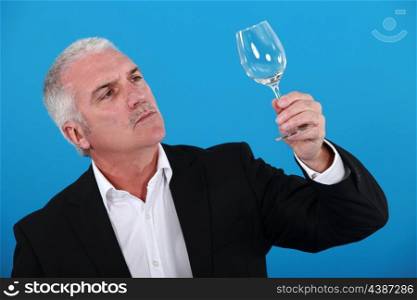 Man examining a wine glass