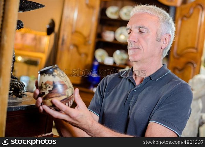 Man examining an antique pot