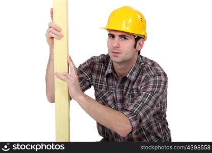 Man examining plank of wood