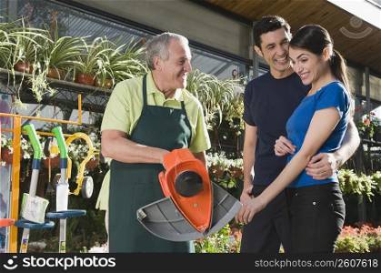 Man explaining about gardening equipment to a couple