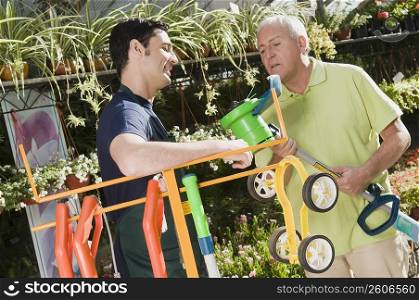 Man explaining about gardening equipment to a customer