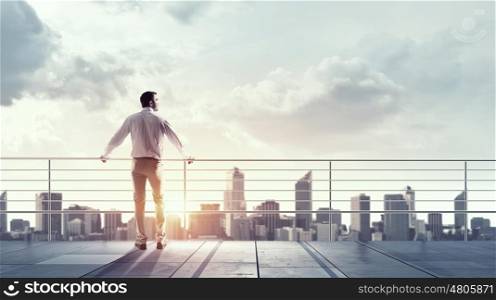 Man facing new day. Man boss standing on building top and looking at city