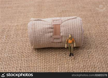 Man figurine in hand on a linen canvas background