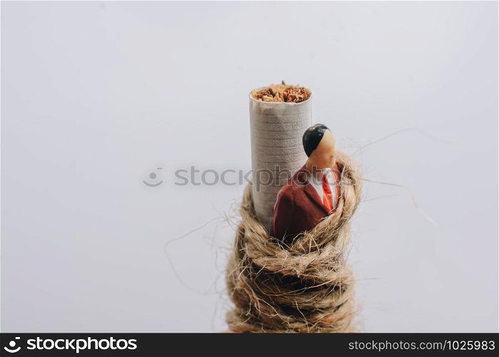 Man figurine tied to a cigarette as anti smoking concept