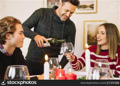 man filling wine glass christmas dinner